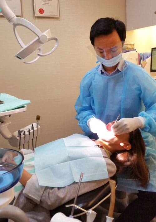 The Dental Studio Dental Hygienist Joel Huang Examining The Mouth Of A Patient