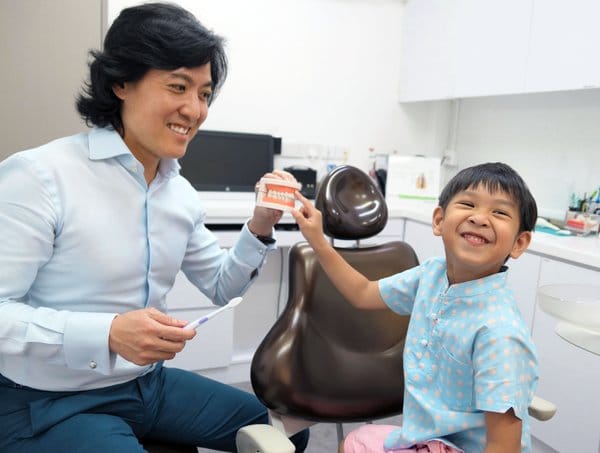 The Dental Studio Dentist Smiling While Child Is Amused At A Jaw Mold